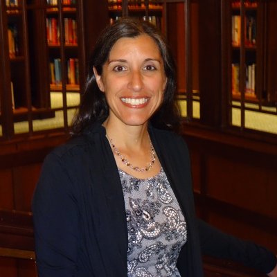 Dr. Kristie Asaro-Saddler smiling in library