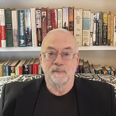 Charles Lanier poses in front of a bookcase. 