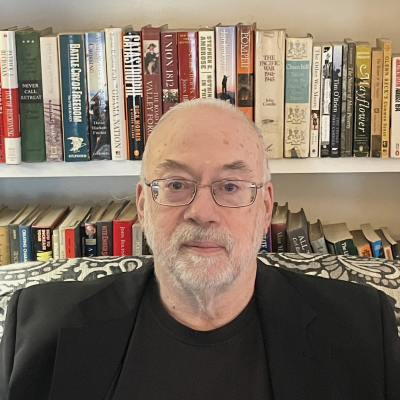 Charles Lanier poses in front of a bookcase. 