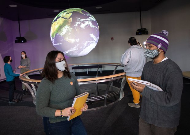 UAlbany Atmospheric Science Professor Aubrey Hillman and DAES students inside the Science on a Sphere Room at ETEC on February 18, 2022. (photo by Patrick Dodson)