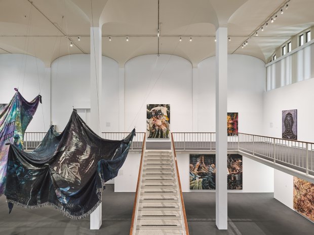 Digitally woven tapestries hanging from the ceiling and on stretchers on the wall