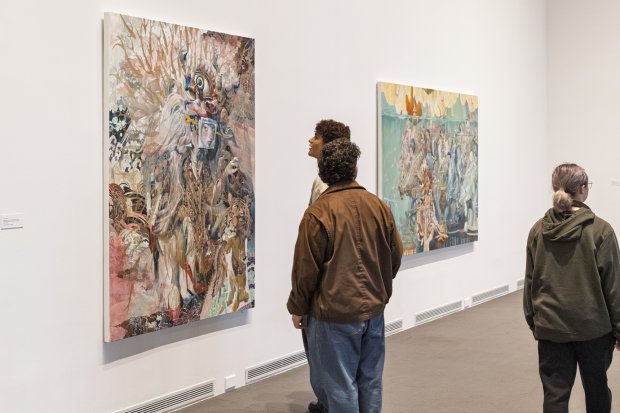 Visitors looking at paintings