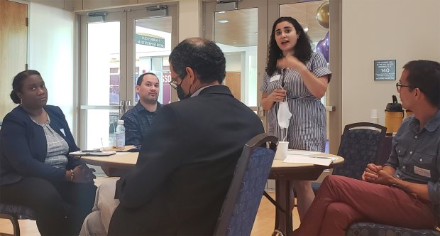Woman stands, addressing the attendees of the BILPOC faculty mentoring group during the group's inaugural meeting held in the UAlbany campus center. 