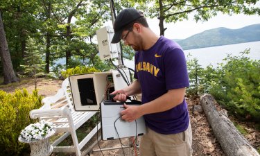 Jason Covert, a research technician at the Atmospheric Sciences Research Center and New York State Mesonet, prepares a land-based flux measurement system on Crown Island at Lake George.