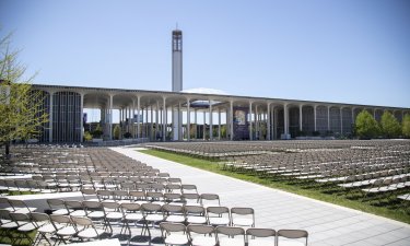 Rows of folding chairs lined on the Entry Plaza lawn of the Uptown Campus for Commencement 2022.