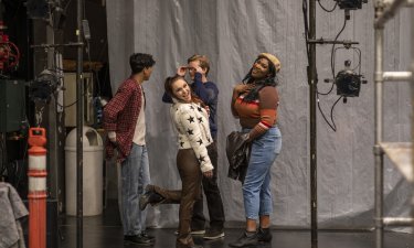 The student cast of "Rent" poses for a picture backstage at dress rehearsals.