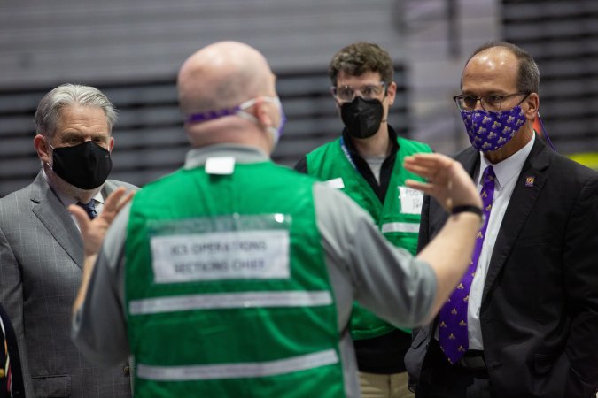 Stephen Conard meets with UAlbany President Havidán Rodríguez and Russell Sage College President Christopher Ames at the COVID-19 vaccination site inside SEFCU Arena.