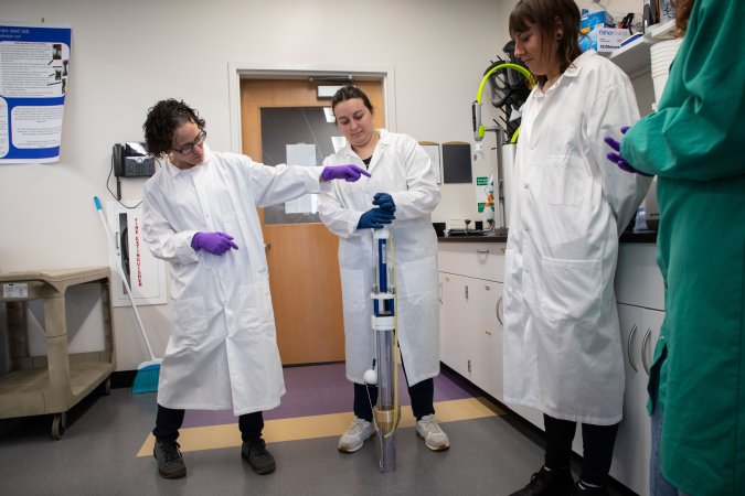 Hillman and her graduate students display a UWITEC coring device inside the Paleoclimate Lab.