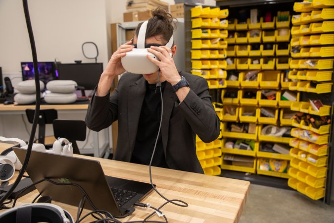 A student at CEHC wears a VR headset in the makerspace at ETEC.