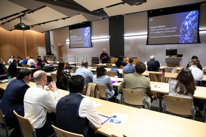 Carmen Medina presents in front of a large group inside ETEC room 149/151 during the Open Source Intelligence Lab launch.