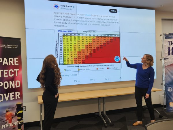 Micki Olson and Jeannette Sutton review a tweet posted by the National Weather Service about extreme heat from inside CEHC's Ops Command Center.