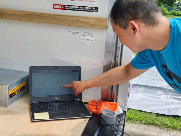 Prof. Brian Tang reviews data from a ground computer during a weather balloon flight at the Schoharie Crossing State Historic Site. 