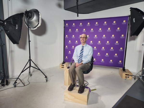 Ryan Torn, DAES professor and chair, sits in front of a UAlbany-branded backdrop while interviewing live on the Fox Weather channel.