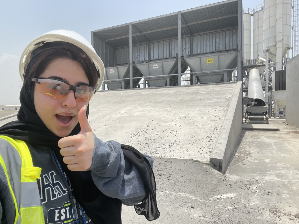 Bythaina Al Balushi gives a thumbs up with a hardhat on while working in Oman.
