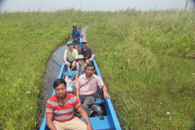 Research collaborators sit in a blue research boat on Loktak Lake.