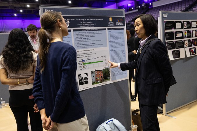 UAlbany Provost Carol Kim speaks with a student presenting on the floor of Broadview Center during Showcase 2025. 