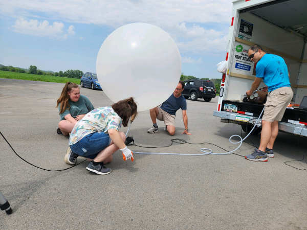 UAlbany researchers prepare a weather balloon to launch from the Schoharie Crossing State Historic Site.