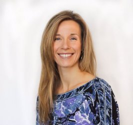 Dr. Stephanie Affinito smiling with white background and blue, purple & black top