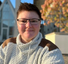 Meilssa Starman wearing a cream sweater and glasses smiling outdoors