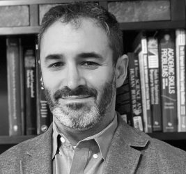 Dr. Benjamin Solomon black and white portrait in front of bookshelf