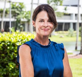 Dr. Kristen C. Wilcox outside smiling posing with arms crossed in blue top