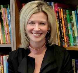 Dr. Lori Bruner smiling in front of a bookshelf