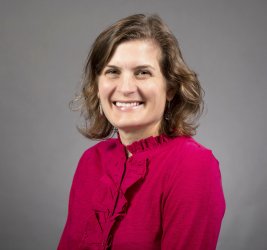 Dr. Joelle Mann portrait smiling with gray background