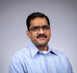 Rajendra smiles at the camera.