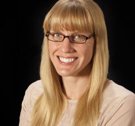 Dr. Erica Barnes smiling with glasses long blonde hair black background
