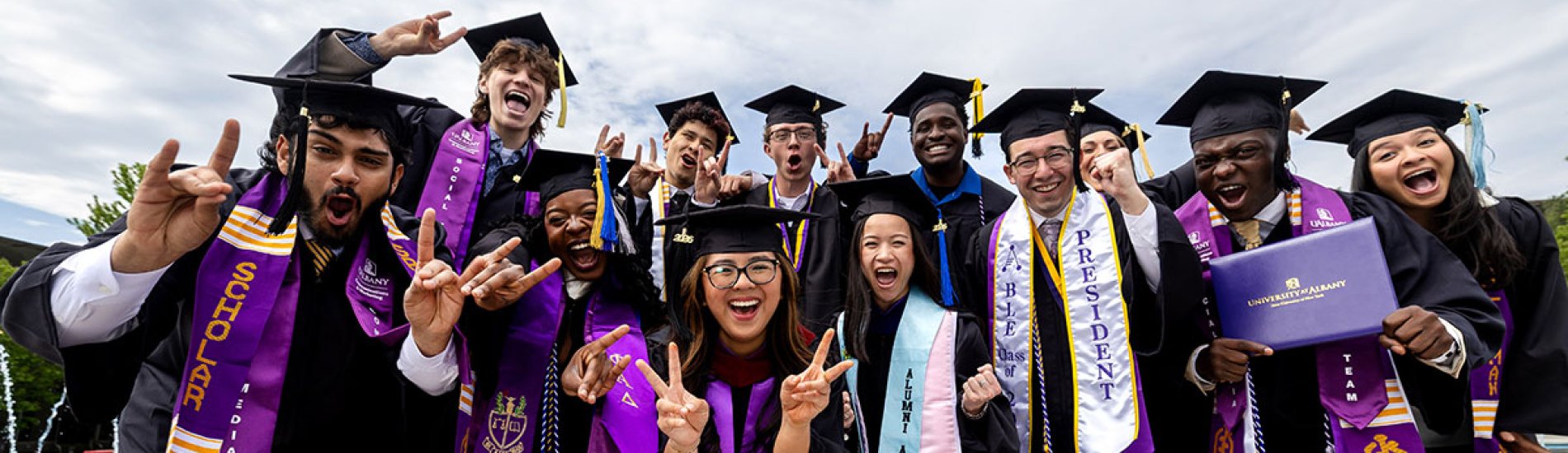 Students posing together in full commencement regalia.