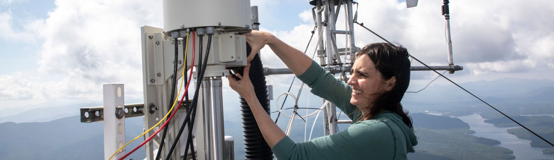 A researcher adjusts machinery for cloud water research on the summit of Whiteface Mountain