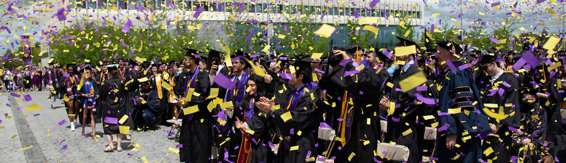 Confetti falling on robed students at the commencement ceremony