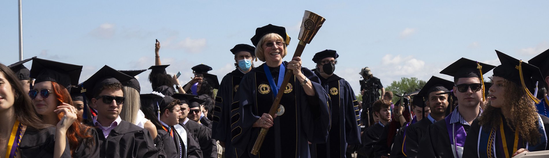 The Torchbearer walking down the aisle to begin the commencement ceremony.