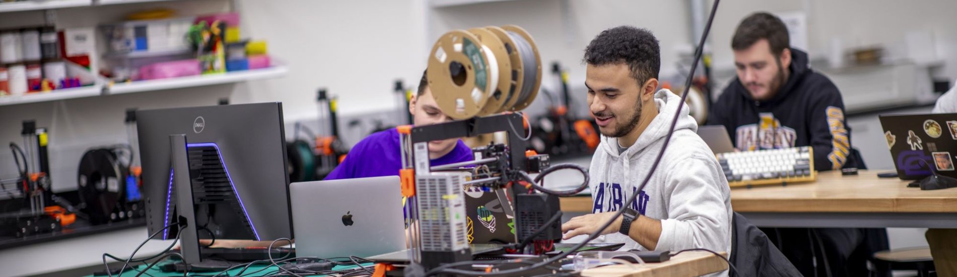 Students working together on a 3D printing project in a lab.