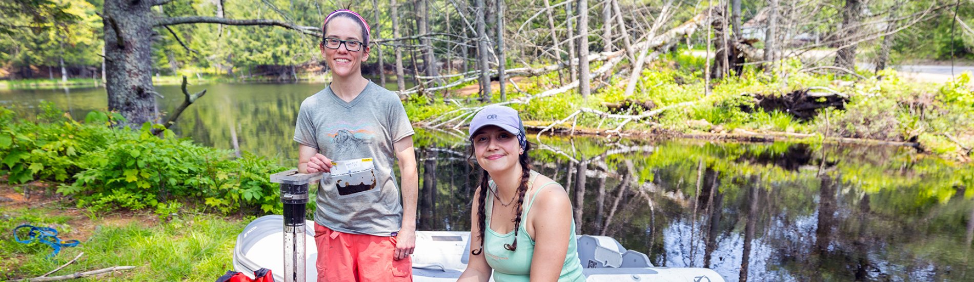 Two students conducting environmental research near a lake.
