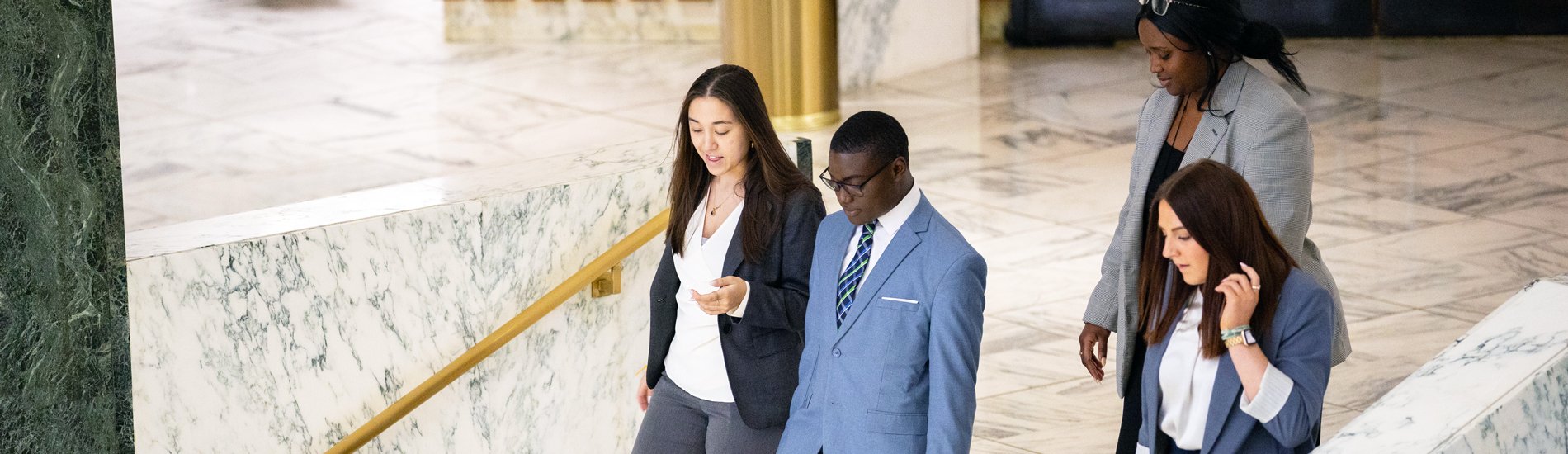 A group of students walking inside the New York State Capitol building.