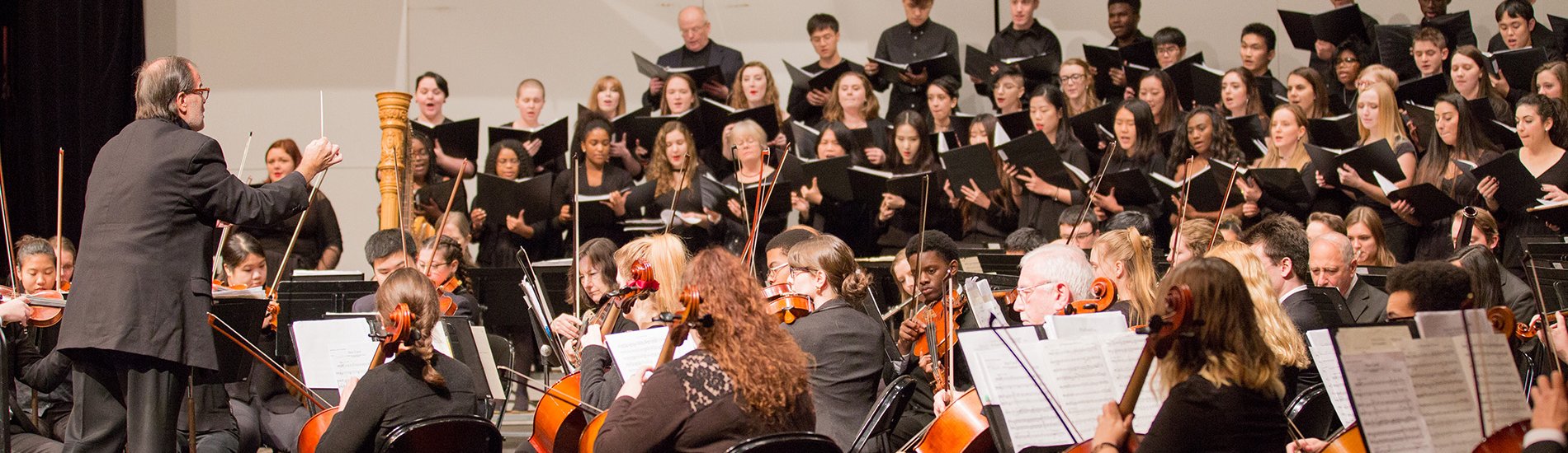 An orchestra and choir performance in the UAlbany Performing Arts Center.
