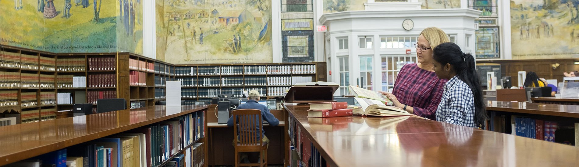 A librarian helping a student with research in the Dewey Library.