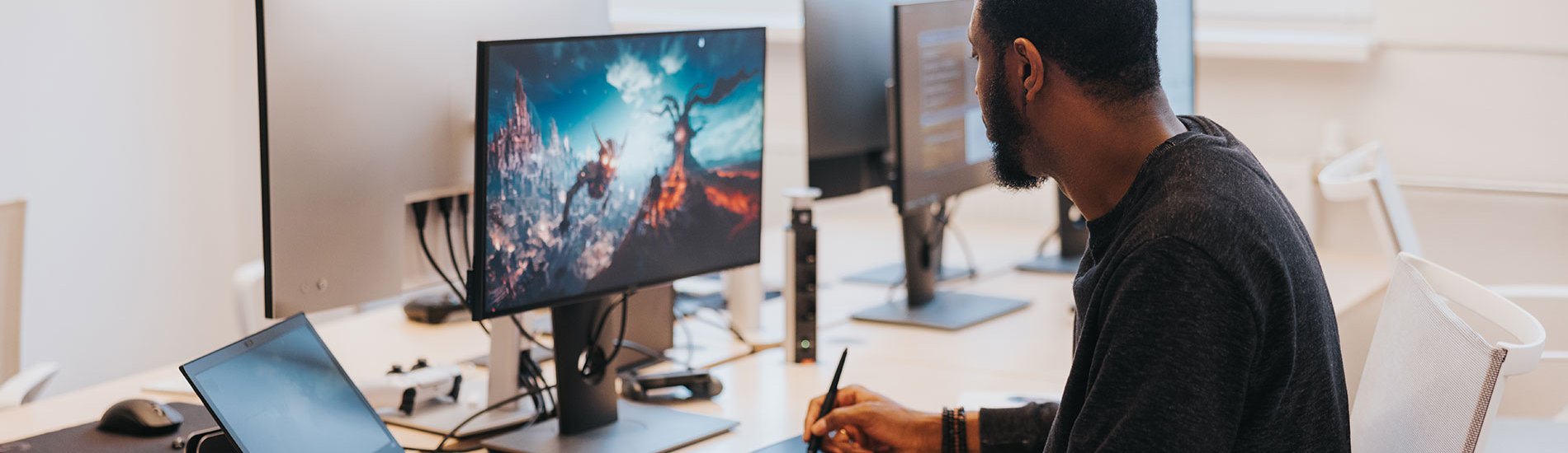 A game developer works on a new game’s visual design at his desk.