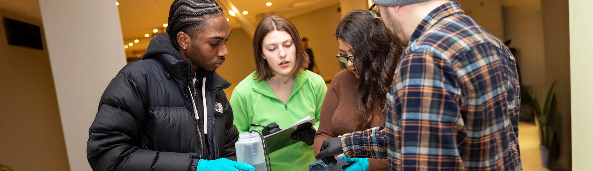 Four students conducting water testing at the Empire State Plaza.