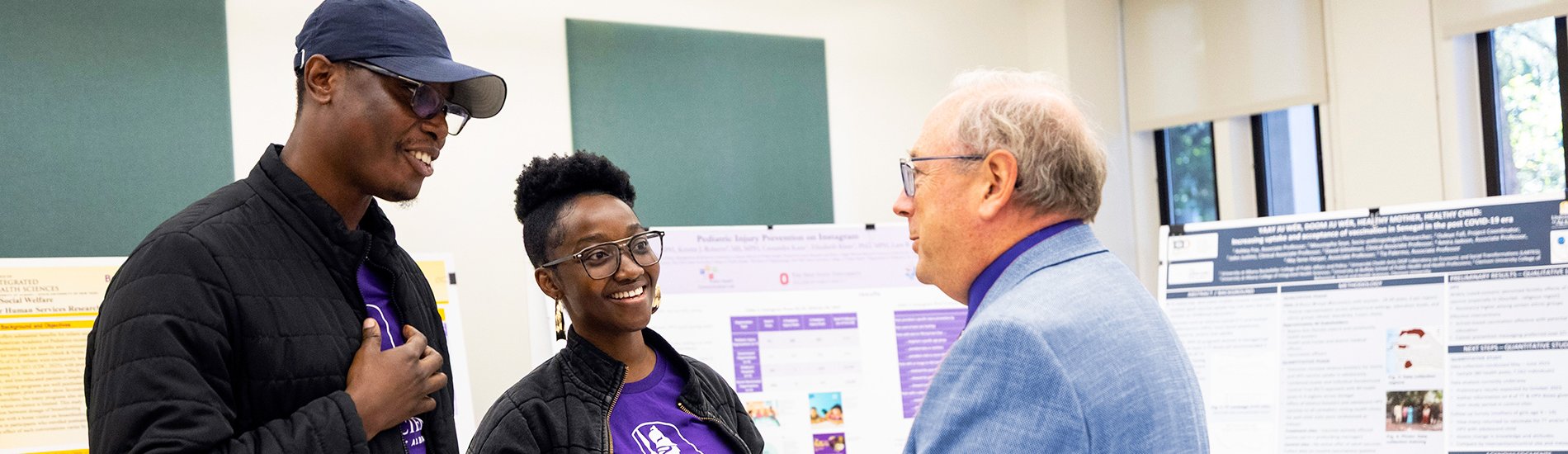 Three people having a discussion during a Health Sciences poster session.