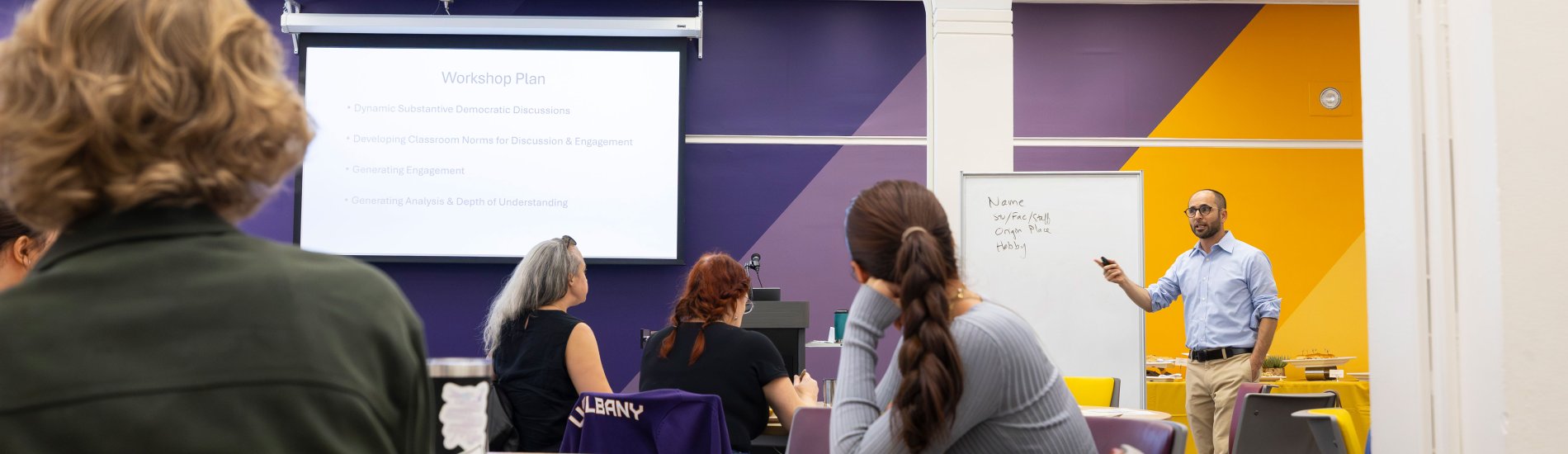 An instructor lectures a classroom full of students.
