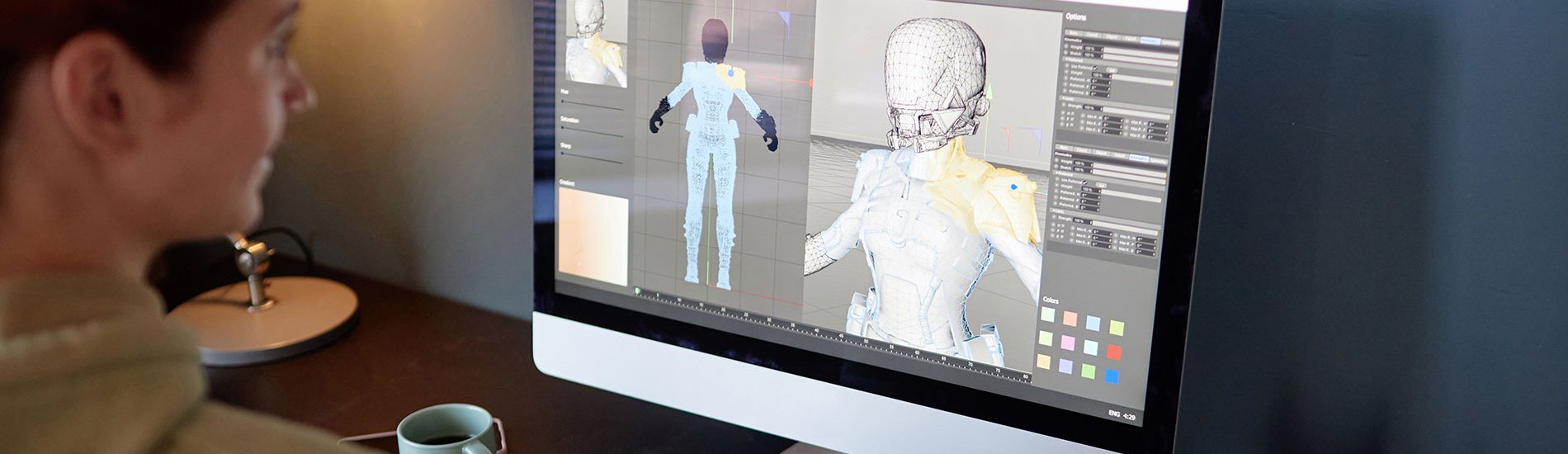 A game designer works on a character model on a computer.