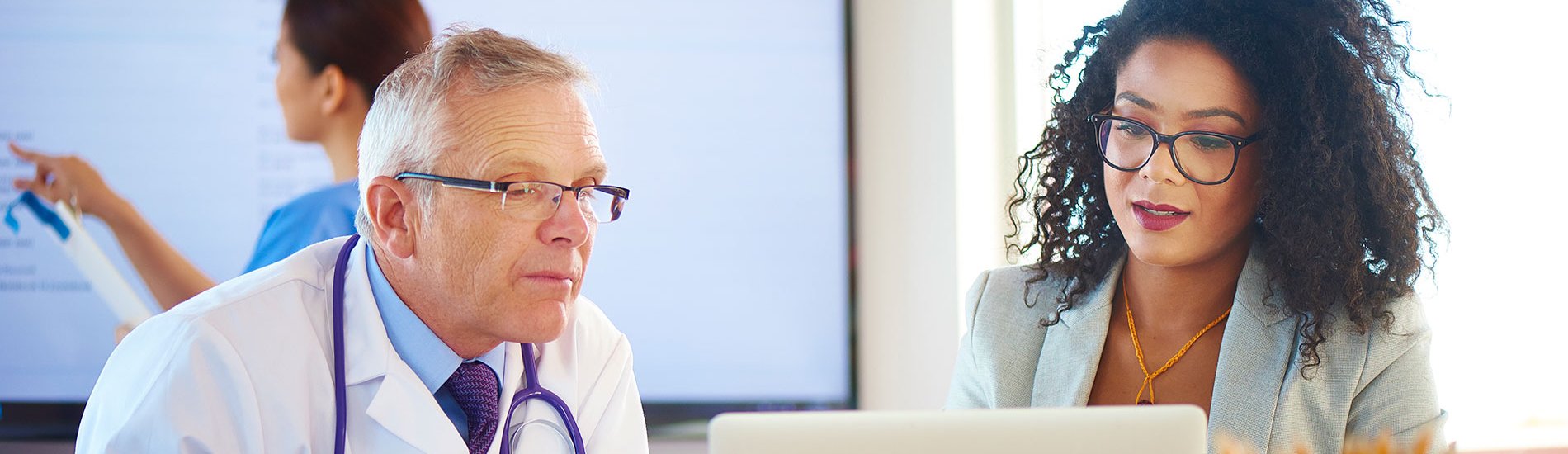 A clinical informatics specialist discusses an EHR-related issue with a doctor.