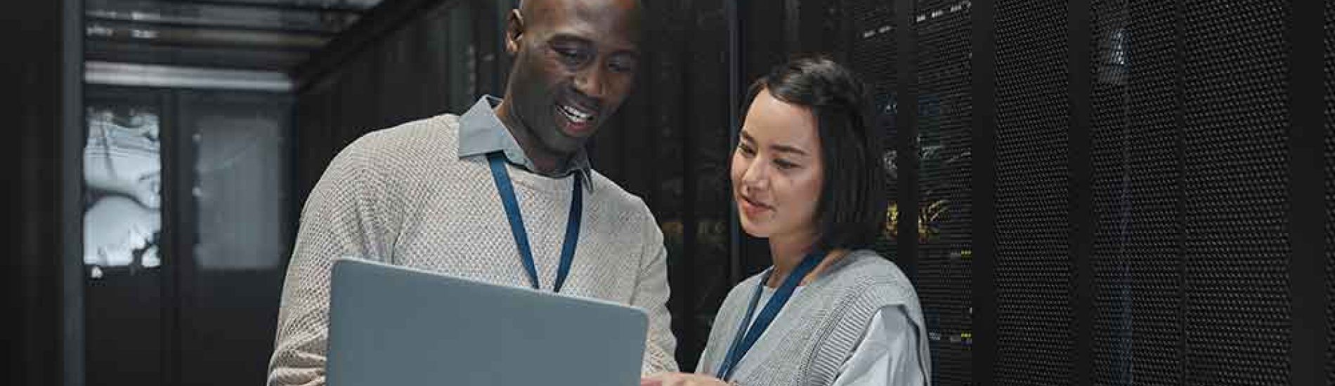 Cybersecurity professionals review data on a laptop in a data center.