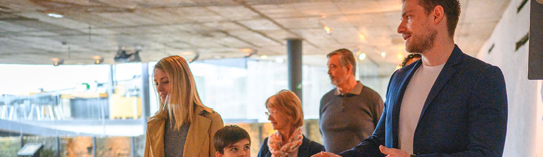 A historian leads a group through a museum exhibit.