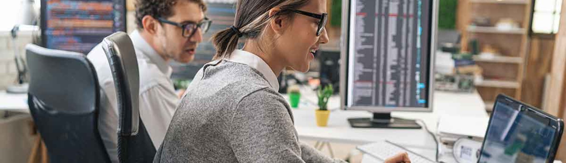 Two cybersecurity professionals working in an office.