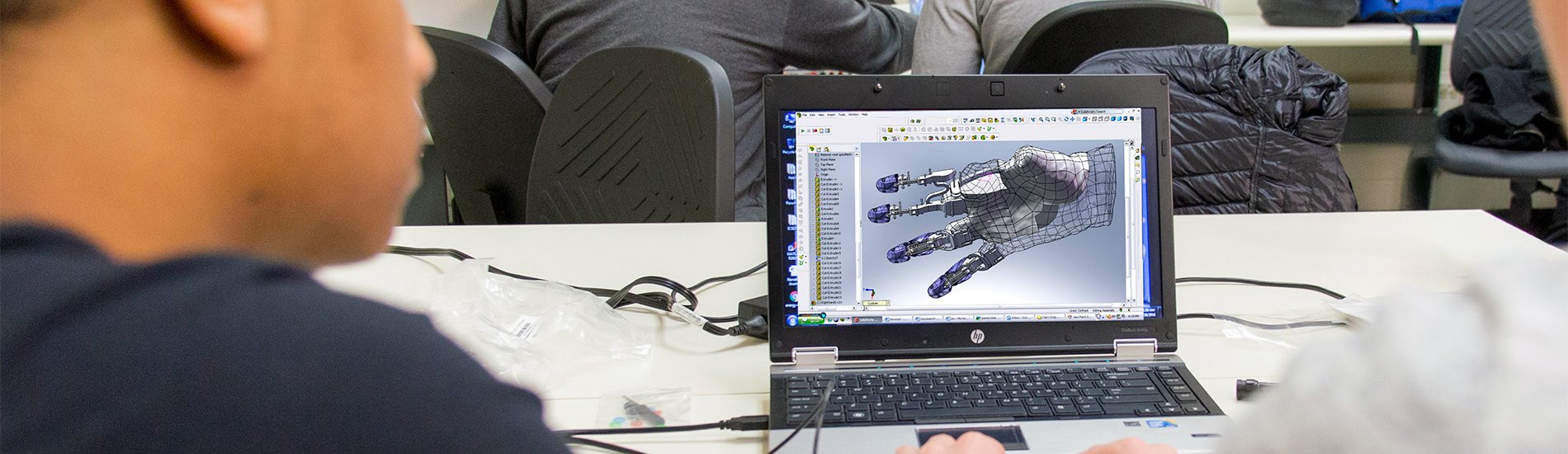 Two students working on a laptop with equipment in a UAlbany engineering lab.