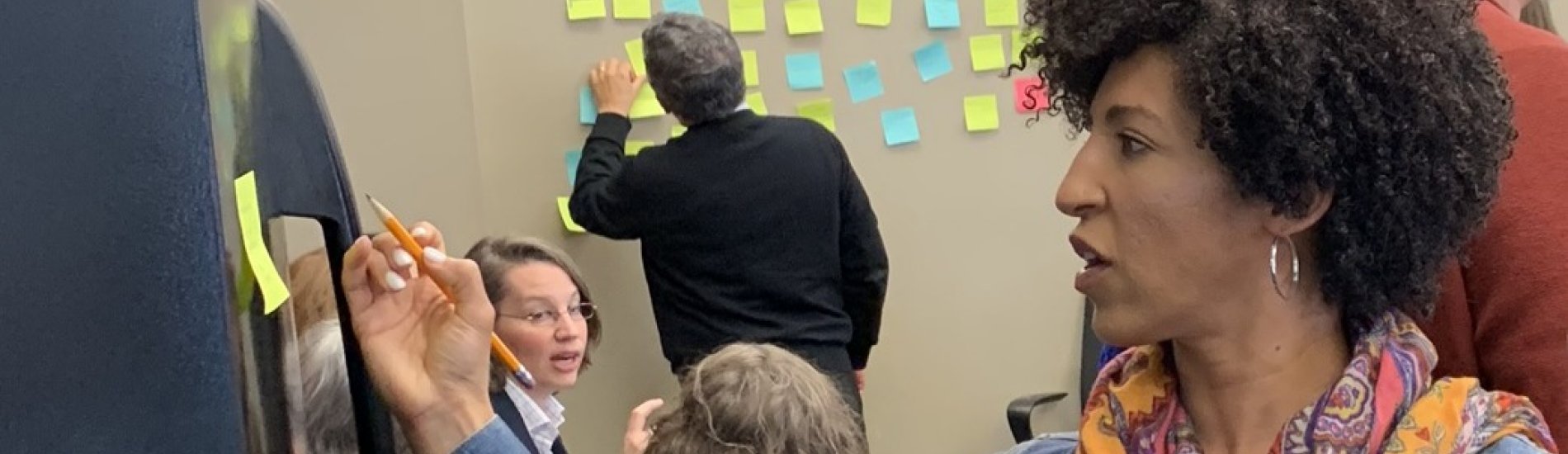 individual in scarf writing on a board