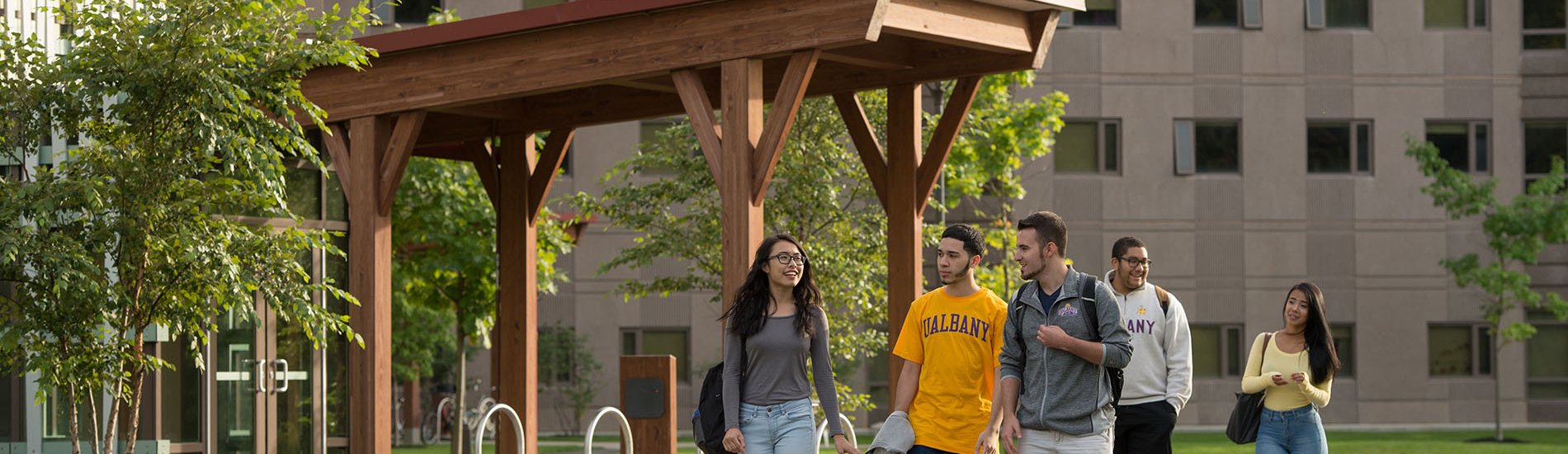 A group of students walks down the pathway outside Freedom Apartments